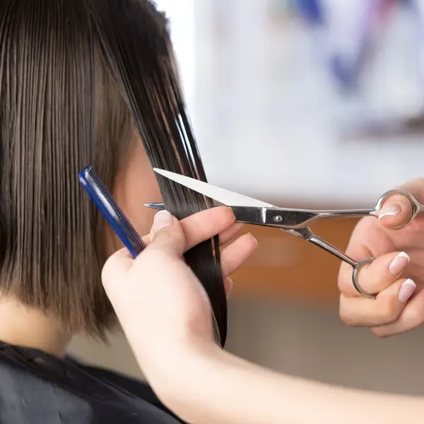 Estilista realizando un corte de pelo a una clienta en Burgos